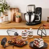 A kitchen counter with a stand mixer, baking accessories, and desserts. Produktbild-Vorschau