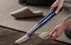 A person is using a vacuum cleaner attachment to clean a slipper on a rug. Anteprima dell’immagine prodotto