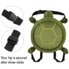 A green turtle-shaped hip protector cushion with straps and buckles, shown from the back. Podgląd zdjęcia produktu