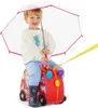 A young child sits on a red ride-on suitcase shaped like a bus, holding a clear umbrella. Produktbild-Vorschau