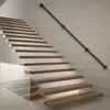 A modern staircase with floating wooden steps and a black metal handrail mounted on a white wall. Náhled obrázku produktu