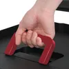 A hand is gripping a red handle of a black object. Voir les images du produit