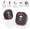 Two black and red stereo speakers are shown on a white reflective surface, with feature icons and text above them. Produktbild-Vorschau