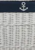 A close-up view of the top portion of a white wicker laundry basket with a navy blue trim and a white anchor design. Podgląd zdjęcia produktu