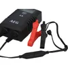 A black battery charger with red and black clamps is shown against a white background. Produktbild-Vorschau