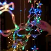 A hand is holding a string of colorful LED Christmas lights shaped like reindeer, bells, and Christmas trees. Produktbild-Vorschau