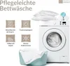 Image shows icons and text describing the care instructions for bedding, alongside a washing machine and laundry basket. Produktbild-Vorschau