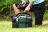A person is kneeling on grass, holding a spray nozzle connected to a portable cleaning device. Anteprima dell’immagine prodotto