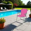 A pink camping chair is set up on a patio next to a swimming pool. Produktbild-Vorschau