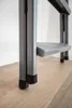 Close-up view of the lower part of a metal step stool on a wooden floor. Voir les images du produit