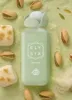 A bottle of perfume surrounded by pistachios and pistachio-flavored snacks. Náhled obrázku produktu