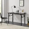 A modern home office setup with a black folding desk, a black chair, a laptop, a desk lamp, and a potted plant. Náhľad obrázku produktu
