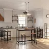 A modern kitchen with industrial-style furniture, including a bar table and stools, and a rolling kitchen cart. Produktbild-Vorschau