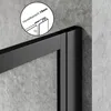 A close-up view of a black metal frame of a shower enclosure, with a magnified inset showing a detail of the adjustable range. Podgląd zdjęcia produktu