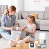 A mother and daughter are playing with toys in a living room, with a robot vacuum cleaner and its accessories in the foreground. Produktbild-Vorschau