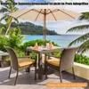 A table and chairs set with an umbrella on a deck overlooking a tropical beach. Anteprima dell’immagine prodotto