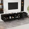A modern black TV lowboard with open shelves and drawers, placed in a living room setting with a TV mounted on the wall above it. Produktbild-Vorschau