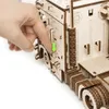 A hand is shown pressing a button on a wooden model truck. Podgląd zdjęcia produktu