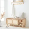 A wooden shoe bench with storage and a cushioned seat, placed in a well-lit entryway with a coat rack above. Produktbild-Vorschau