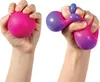 Two hands are shown holding and squeezing stress balls. The left hand holds a solid pink stress ball. The right hand holds a stress ball that transitions from pink to purple and is being squeezed into a distorted shape. Voir les images du produit