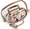 An open baby bag with various items inside, including a book, keys, a stuffed animal, and a pink toy. Produktbild-Vorschau