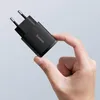 A hand holding a black USB-C charger. Produktbild-Vorschau