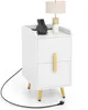 A white nightstand with gold accents, featuring two drawers and a lamp and wireless charger on top. Produktbild-Vorschau