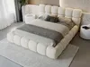 A bedroom scene featuring a large, upholstered bed. Produktbild-Vorschau