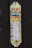 A thermometer with a Volkswagen bus graphic is mounted on a wooden surface. Produktbild-Vorschau