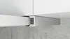 Close-up of a modern range hood with integrated controls, mounted under white kitchen cabinets, above a concrete wall. Náhled obrázku produktu