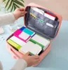 A person is organizing a pink medication organizer bag filled with various medicine boxes. Náhľad obrázku produktu