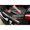 A person is placing a foldable dog transport box into the trunk of a car. Produktbild-Vorschau