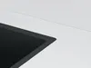 A close-up view of a black sink edge against a white countertop. Produktbild-Vorschau