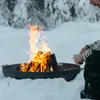 A person is tending to a bonfire in the snow. Produktbild-Vorschau