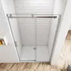 A modern shower enclosure with sliding glass doors, set against a white brick wall and a wooden floor. Produktbild-Vorschau