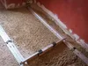 A construction site or renovation area with loose fill material on the floor and leveling equipment. Voir les images du produit