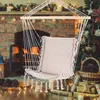 A hammock chair is displayed in front of a fireplace and a Christmas tree, suggesting a cozy indoor setting during the holidays. Produktbild-Vorschau