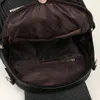 Close-up view of the interior of a black backpack, showing pockets and a zipper. Podgląd zdjęcia produktu