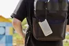 A person wearing a black t-shirt and a black backpack with a gray power bank attached to it. Produktbild-Vorschau