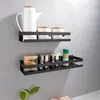 Two black shelves mounted on a gray wall, displaying various kitchen or bathroom items. Podgląd zdjęcia produktu