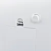 A close-up view of the back of a white electronic device, showing a power button and a port. Produktbild-Vorschau