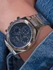 A close-up shot of a person's wrist wearing a silver Guess watch with a blue dial. Voir les images du produit