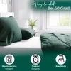 A bed with dark green bedding, featuring icons and text related to product care. Produktbild-Vorschau