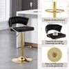 A black bar stool with gold accents is shown in a kitchen setting, with close-up diagrams highlighting its features. Produktbild-Vorschau