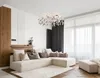 A modern living room with a sectional sofa, chandelier, and large windows. Anteprima dell’immagine prodotto