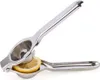 A stainless steel manual citrus juicer with a slice of lemon inside. Produktbild-Vorschau