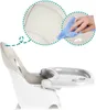 Close-up of a high chair with a tray, with a magnified inset showing a hand cleaning the seat. Produktbild-Vorschau