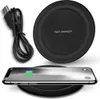 A black wireless charging pad with a USB cable and a smartphone charging on it. Produktbild-Vorschau