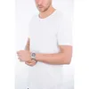 A man wearing a white t-shirt and a silver digital watch on his left wrist. Podgląd zdjęcia produktu