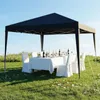 A black pop-up gazebo set up in a grassy field with a white-clothed table and chairs, set for a formal outdoor meal. Anteprima dell’immagine prodotto